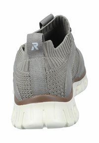 Zapatilla atlética gris con textura tejida, cuello elástico, tirador y suela blanca con acento marrón. Vista trasera que muestra los detalles del diseño.