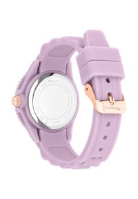 Montre en silicone lilas avec un dos en acier inoxydable, quincaillerie en or rose et bracelet texturé. Elle dispose d'un cadran rond et d'une fermeture ajustable.