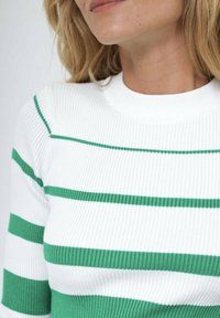 Pull en maille côtelée avec des rayures horizontales vertes et blanches, un col rond et une coupe ajustée. La texture est douce et extensible.