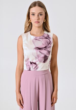 Ärmelloses Oberteil aus weißem Satin mit rosa Blumenmuster; kombiniert mit hochtaillierten rosa Hosen mit Falten. Glatte Textur und taillierte Passform.