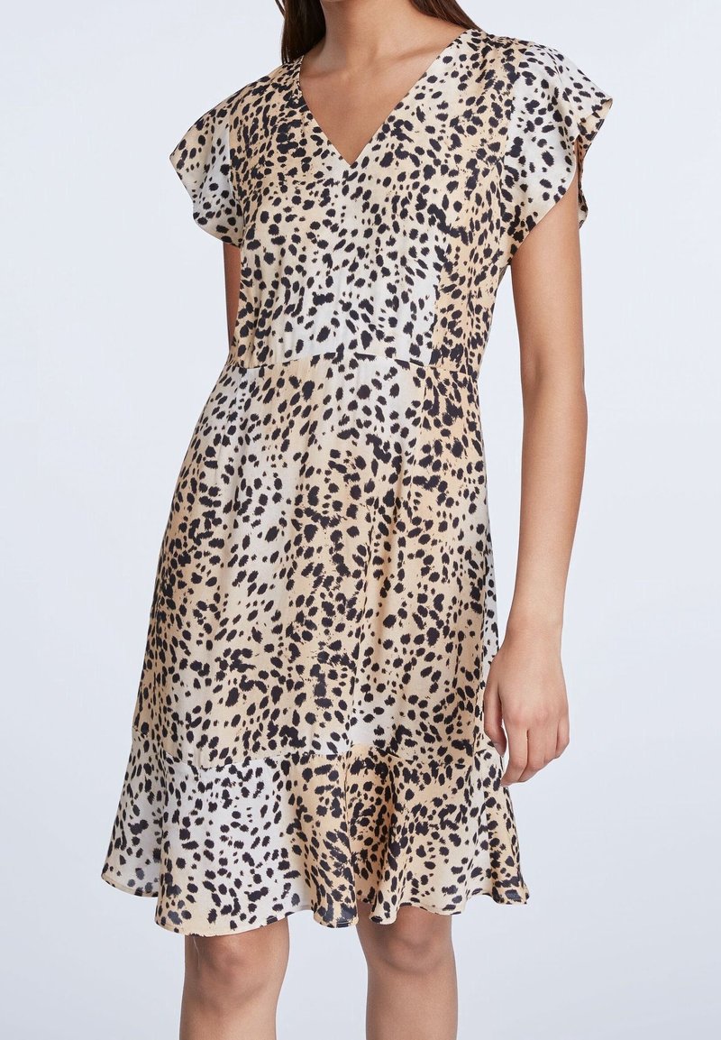 Leopardenmusterkleid in hellbeige und schwarz, mit V-Ausschnitt, schwingenden Ärmeln und ausgestelltem Saum. Glattes Material mit leicht glänzender Struktur.