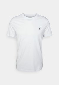 T-shirt bianco a maniche corte in cotone, con colletto rotondo e un piccolo logo di un uccello nero sul lato sinistro del petto. Texture liscia.