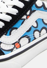 Αθλητικό παπούτσι με μαύρο σουέντ και μπλε ύφασμα με λουλουδάτο σχέδιο, λευκή δερμάτινη λωρίδα στο πλάι και λευκά κορδόνια. Μαύρη και λευκή ελαστική σόλα.