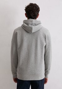 Felpa grigia realizzata in tessuto morbido, con cappuccio regolabile e polsini e orlo a costine. La vista posteriore mostra una texture liscia e un design semplice.