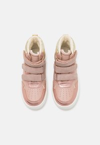 Hohe Sneakers mit glänzendem pinkem Lederoberteil, weichem cremefarbenem Innenfutter, drei Klettverschlüssen und einer weißen Gummisohle.