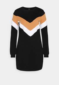 Robe noire à manches longues avec un motif chevron en jaune moutarde et blanc. Fabriquée en tissu doux, dotée d'un col arrondi et de poignets côtelés.