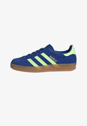 Blauwe Adidas Gazelle sneaker met lichtgroene strepen, lichtgroene hiel tab en natuurlijke rubberen zool.