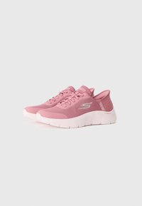 Pink athletic shoes with a breathable mesh upper, textured accents, and a cushioned white sole. Features flat laces and logo detail on the side.