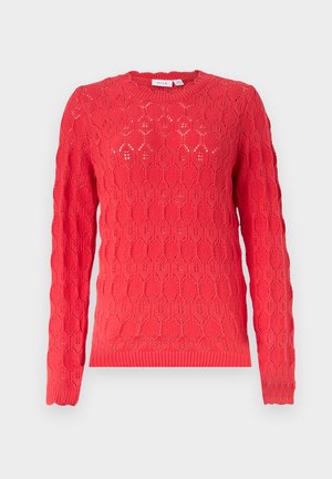 Červený dlouhý svetr s kulatým výstřihem a celoplošným vzorem oválných otvorů s texturou.