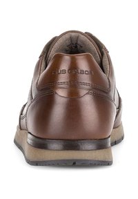 Bruine leren schoenen met een gladde textuur, voorzien van een lage profiel en een cushioned zool. Logo zichtbaar op de hiel.