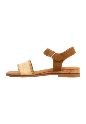 Brun flad sandal med flettet forreste rem, justerbar ankelrem med spænde og kork-textureret lav hælsål.
