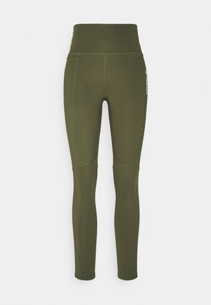 Legginsy z wysokim stanem w kolorze oliwkowej zieleni, z widocznym przeszyciem i boczną kieszenią na lewym udzie.