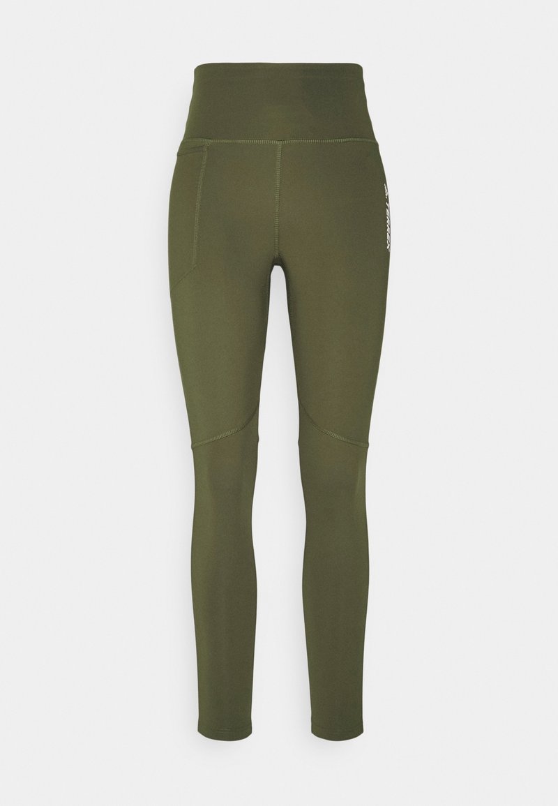 Leggings taille haute vert olive avec coutures visibles et une poche latérale sur la cuisse gauche.