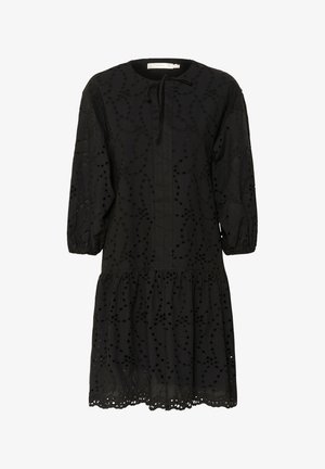 Sort kjole med rund halsudskæring, trekvartærmer og lagdelt nederdel. Har broderede mønstre og udskæringer ved kanten.