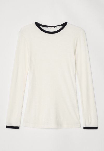 Majica s dolgimi rokavi v off-white tkanini z črnim okroglim ovratnikom in ojačitvami na manšetah. Mehka tekstura, prilega se telesu z gladkim zaključkom.