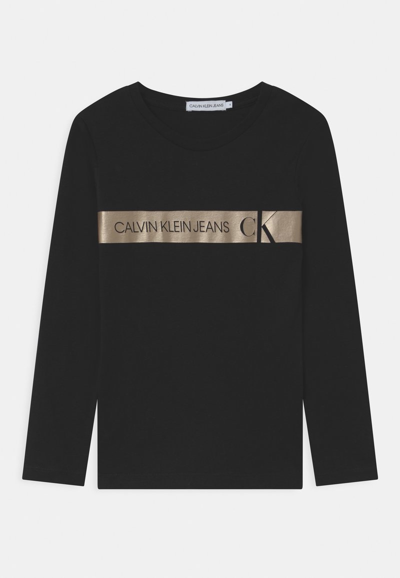 Černá dlouhá rukávová košile vyrobená z bavlny, s metalickým zlatým páskem přes hruď, na kterém je nápis "CALVIN KLEIN JEANS" a logo.