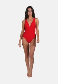 Maillot de bain une-pièce rouge avec un décolleté en V profond et des bretelles larges, doté d'un tissu lisse et d'une silhouette ajustée pour une apparence épurée.