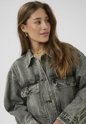 Ülemahukas teksajakk tuhmjas mustas värvitoonis, millel on hõbedased täpid. Varustatud nelja tasku ja metallist nuppudega. Tekstuuriga kangas ja lõdvestatud istuvus.