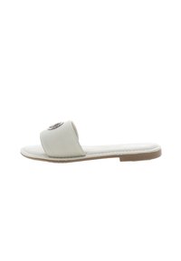 Flat slide sandal in light beige synthetic material, featuring a wide strap with a decorative metallic embellishment. Flexible sole design.