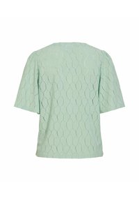 Blouse à manches courtes vert clair avec motif texturé hexagonal en relief, coupe ample et encolure ronde, vue de dos.