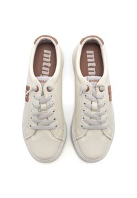 Baskets beige clair avec une tige en cuir texturé, dotées de lacets gris, d'un accent de talon brun et d'un logo sur les semelles intérieures. Design à bout rond.