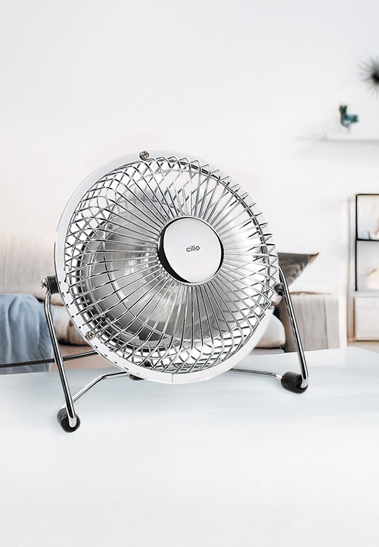 Kromatischer Tischventilator mit einem runden Gitter, montiert auf einem stabilen schwarzen Standfuß. Verfügt über ein silbernes Logo in der Mitte und ein schlankes Design für effiziente Luftzirkulation.