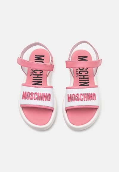 Rosa och vita sandaletter med öppen tå som har justerbara remmar, vit sula och "MOSCHINO" broderat på innersulan och remmen.