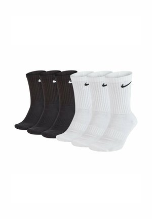 Four-pack of Nike socks: two black and two white, ribbed texture, mid-calf length, featuring the Nike logo on the cuff in contrasting colors.