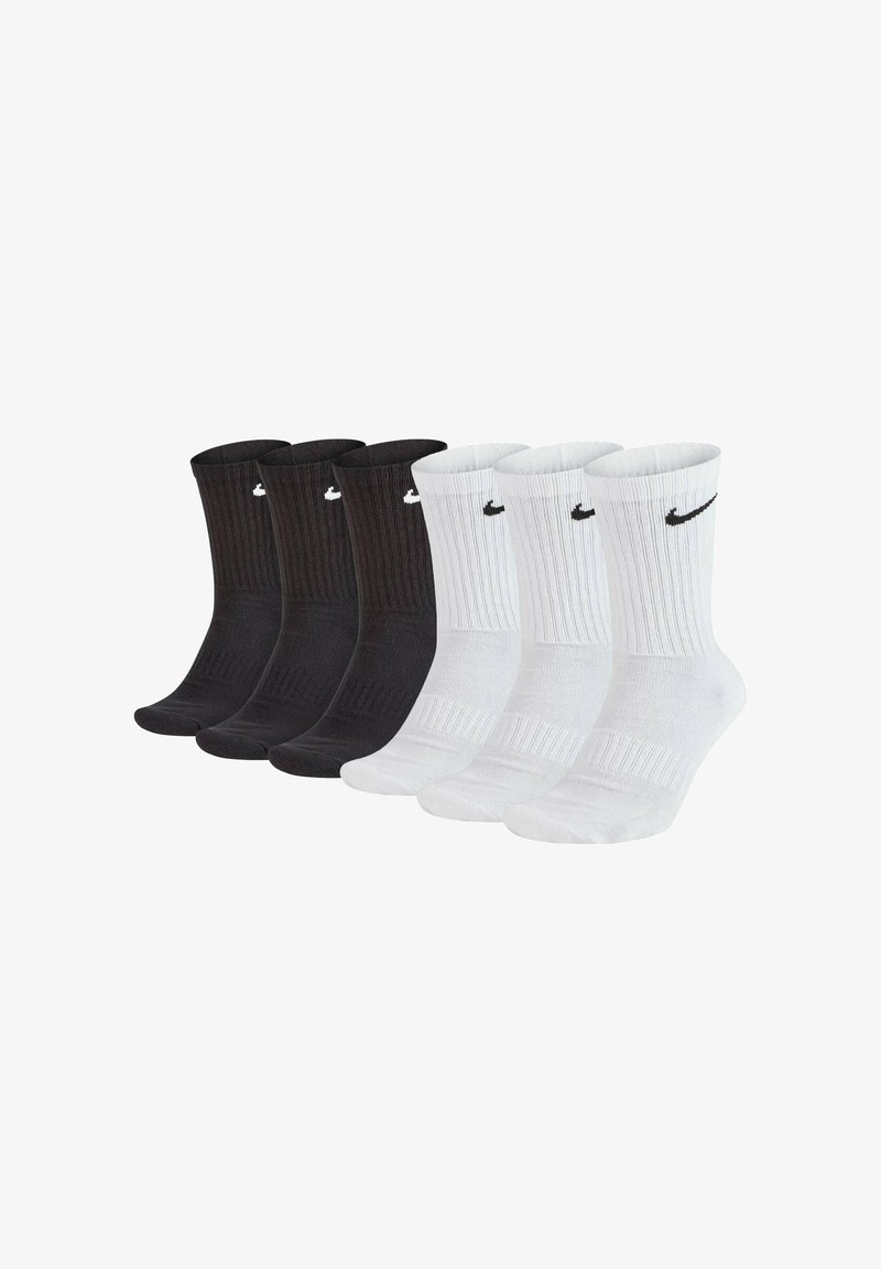 Confezione da quattro paia di calzini Nike: due neri e due bianchi, con texture a coste, lunghezza a metà polpaccio, dotati del logo Nike sul risvolto in colori a contrasto.