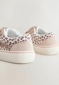 Adidași roz din piele întoarsă, cu imprimeu leopard, accente sclipitoare și talpă albă de cauciuc cu o bandă roz subtilă.