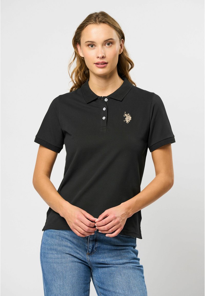 Zwarte poloshirt met een kraag, korte mouwen, een drieknoopsluiting en een geborduurd logo op de borst. Glad katoen materiaal.