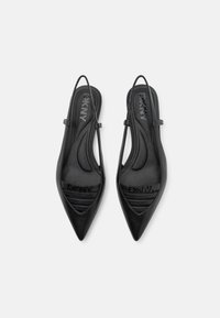 Sapatos slingback em couro preto com bico pontudo, logotipo DKNY em relevo, apresentando um design elegante e detalhes recortados curvados.