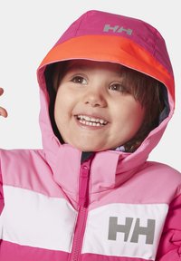 Kleurrijke roze en witte jas met een rits, voorzien van een opvallende oranje capuchon, grijs logo op de borst en een zachte textuur.