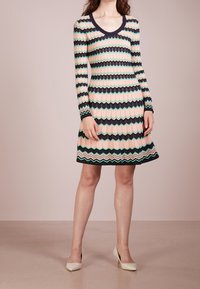 Långärmad klänning med ett vågigt mönster i rosa, grönt och marinblått. Figurnära bodice, utsvängd kjol, rundad halsringning, tillverkad av texturerad stickad tyg.