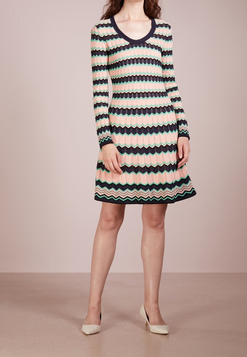Långärmad klänning med ett vågigt mönster i rosa, grönt och marinblått. Figurnära bodice, utsvängd kjol, rundad halsringning, tillverkad av texturerad stickad tyg.
