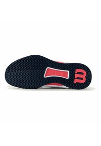 Suela de zapatilla de tenis con un patrón de ondas en goma negra, acentos rosas y una sección blanca con el logo de "Wilson" en el centro.