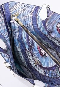 Borsa a tracolla in pelle bianca texturizzata con un vivace motivo interno blu, viola e rosa, dotata di una cerniera dorata e scomparti multipli.
