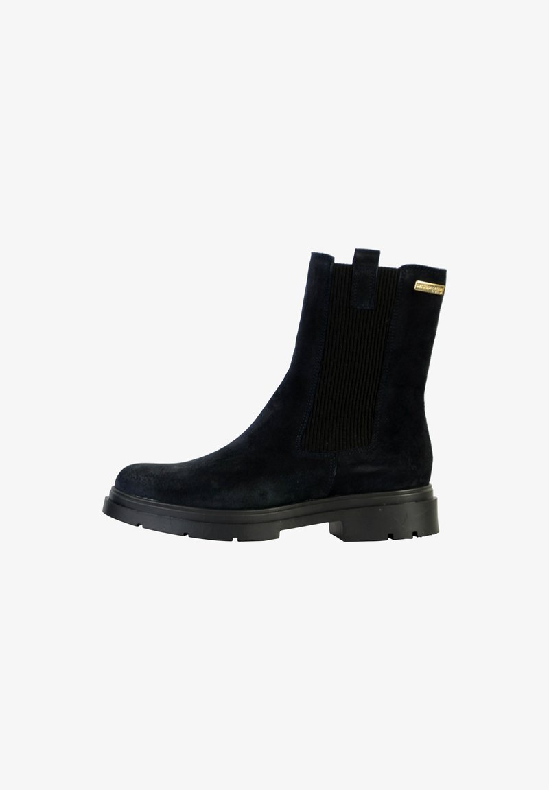 Bota de tobillo de ante negro con panel lateral de elastano, lengüetas, suela de goma gruesa y pequeña etiqueta de marca dorada cerca de la parte superior.