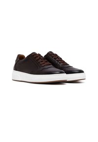 Ciemnobrązowe skórzane sneakersy z brązowymi sznurowadłami, białą gumową podeszwą, gładkim wykończeniem i minimalistycznym designem. Posiadają wyszywane szczegóły.