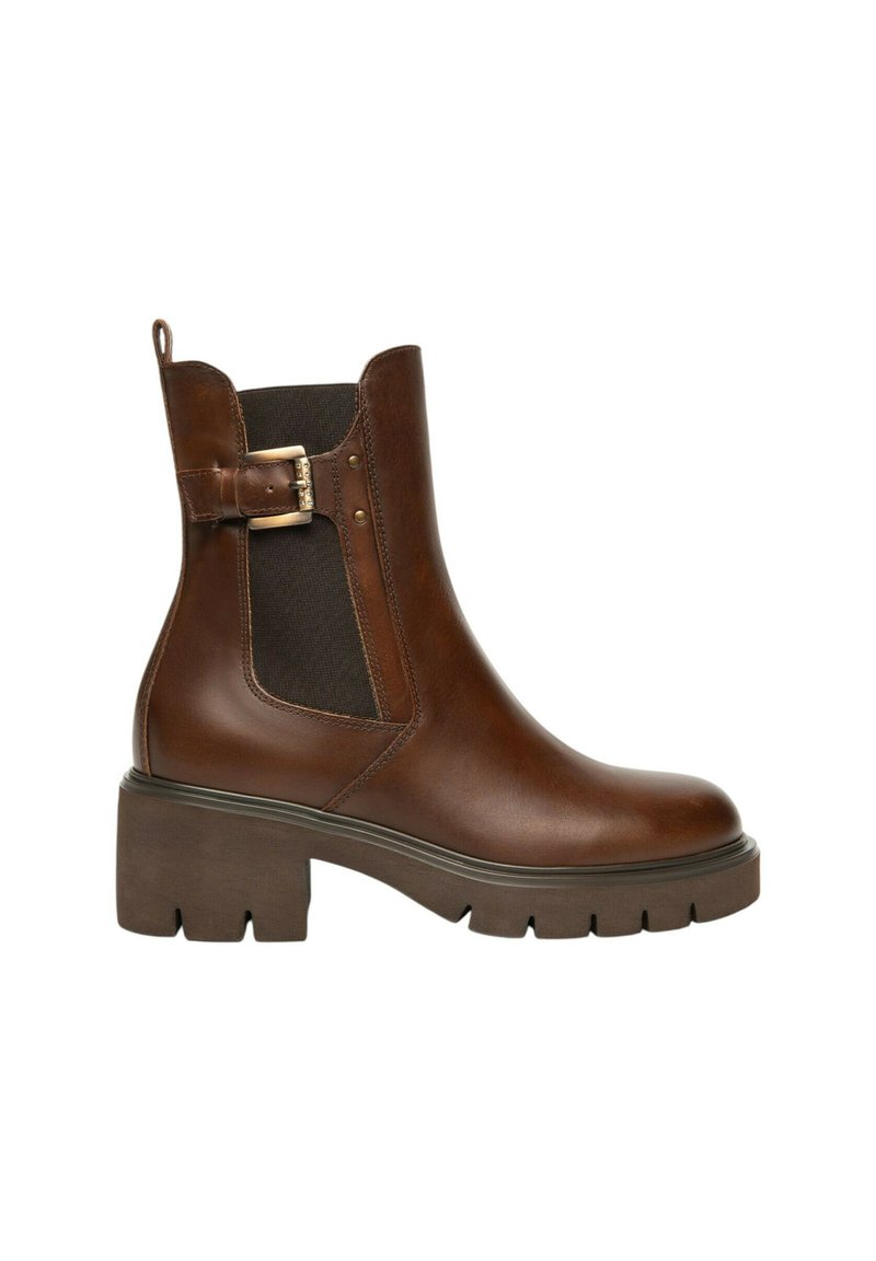 Stivale alla caviglia in pelle marrone con suola chunky, pannelli laterali elasticizzati e cinturino decorativo con fibbia su sfondo bianco.