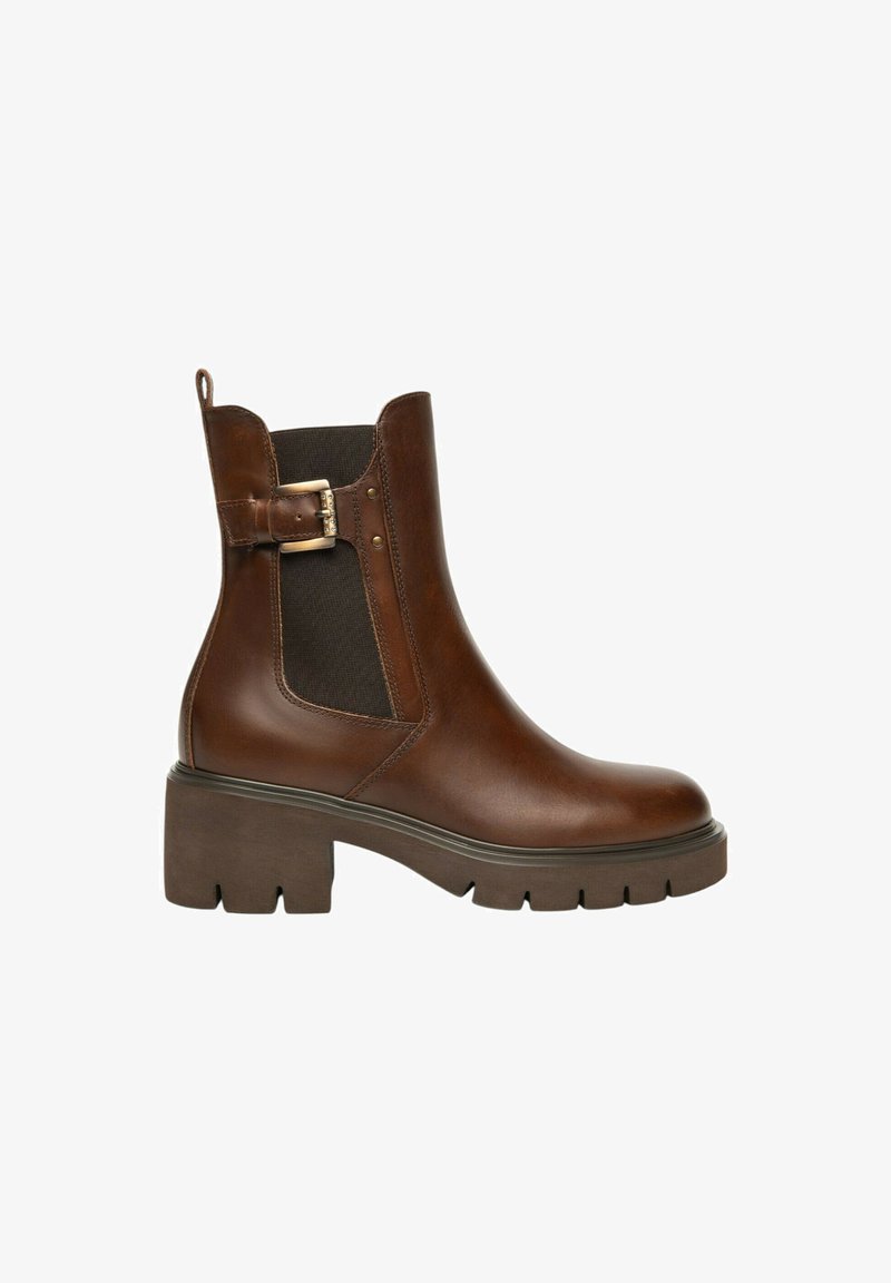Stivale alla caviglia in pelle marrone con suola chunky, pannelli laterali elasticizzati e cinturino decorativo con fibbia su sfondo bianco.