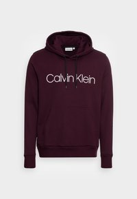 Bordeaux hoodie met een trekkoordkap, voorzak, geribde manchetten en een groot wit "Calvin Klein" logo op de borst. Zachte stof.