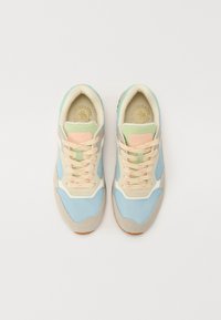 Sportsko skoene med mesh-overdel i lyseblå, beige detaljer og myke mintgrønne elementer. Har pastell-snøring og en teksturert såle.