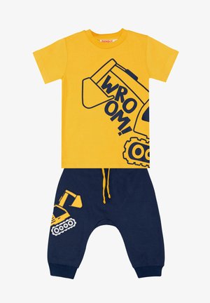 T-shirt en coton jaune avec un graphique d'excavatrice et le texte "WROOM !" ; associé à un pantalon de jogging en coton bleu marine présentant un design d'excavatrice assorti.
