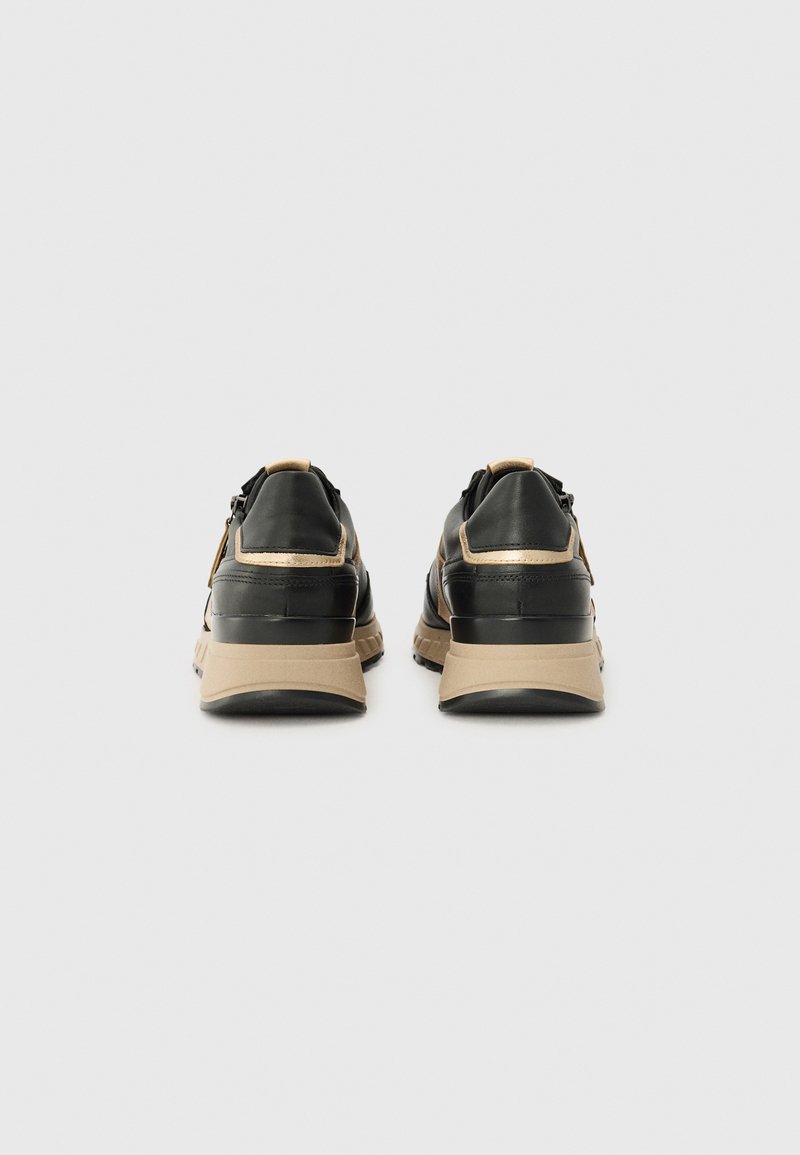 Zwarte lederen sneakers met beige accenten, ronde vorm, gevoerde kraag en een getextureerde zool. Heeft een minimalistisch ontwerp en subtiele hardwaredetails.