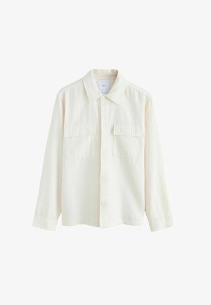 Cream-colored button-up shirt made from textured fabric, featuring a collared neck, two chest pockets, and long sleeves with button cuffs.