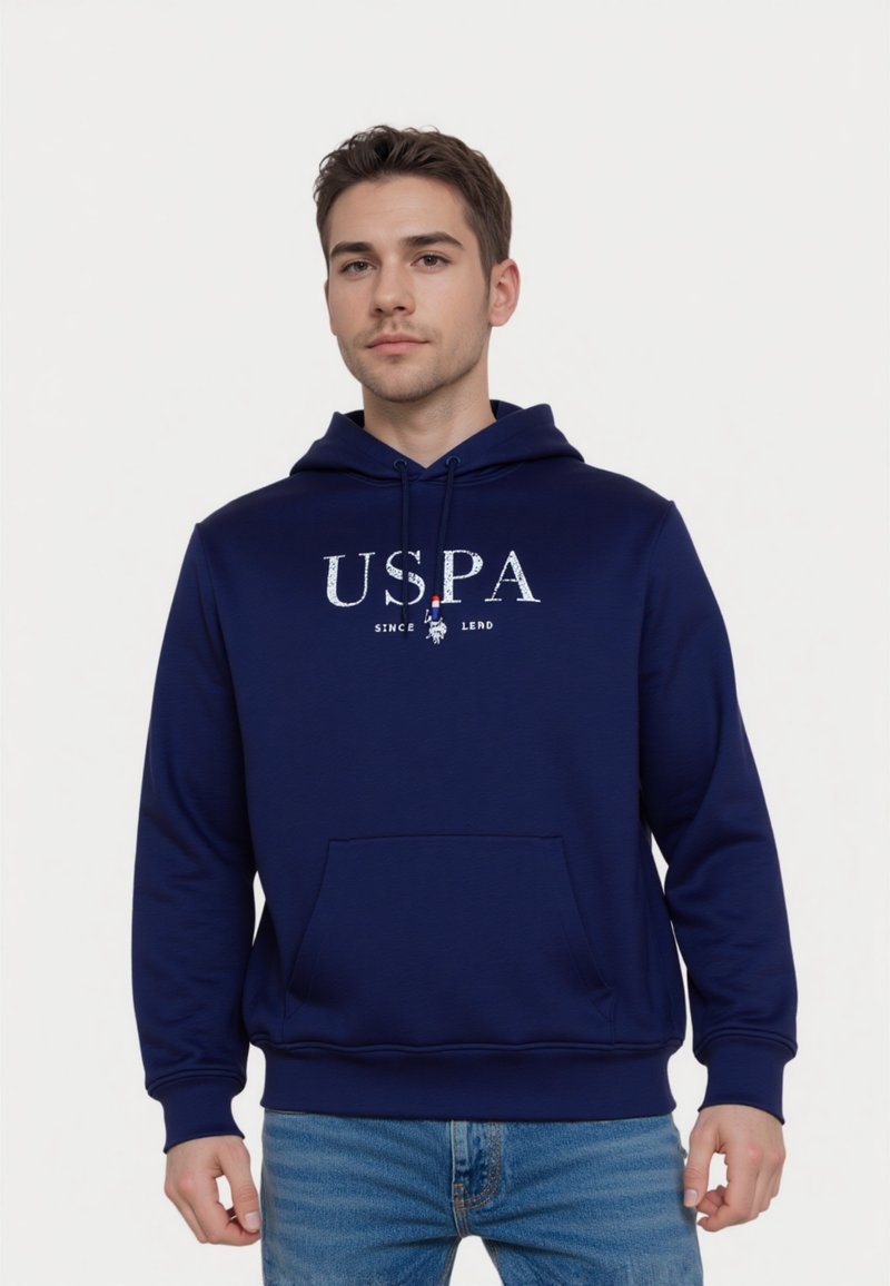 Navy kék kapucnis pulóver elülső zsebbel, fehér "USPA" logóval és puha textúrával. Állítható húzózsinórok a nyaknál.
