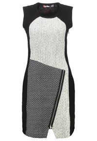 Schwarz-weißes ärmelloses Kleid aus strukturiertem Stoff mit Fischgrätenmuster, asymmetrischer Paneelverarbeitung und einem seitlichen Reißverschlussdetail.