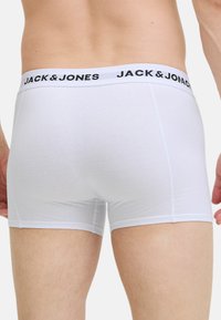 Valkoiset bokserit mustalla elastisella vyötäröosualla, jossa lukee "JACK & JONES". Valmistettu pehmeästä kankaasta, muotoon ommellut malli, jossa on minimaalisesti saumoja.