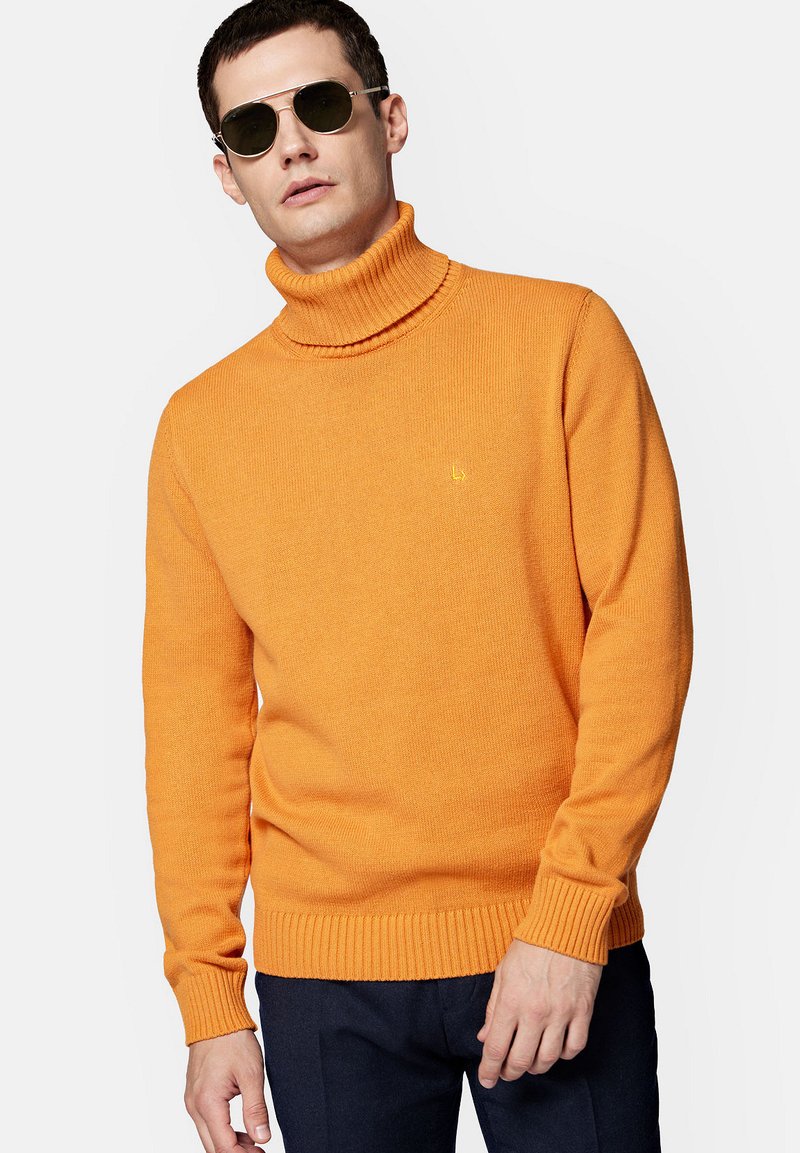Pomarańczowy sweter z golfem, wykonany z dzianiny, z prążkowanymi mankietami i dołem oraz z małym logo na klatce piersiowej.
